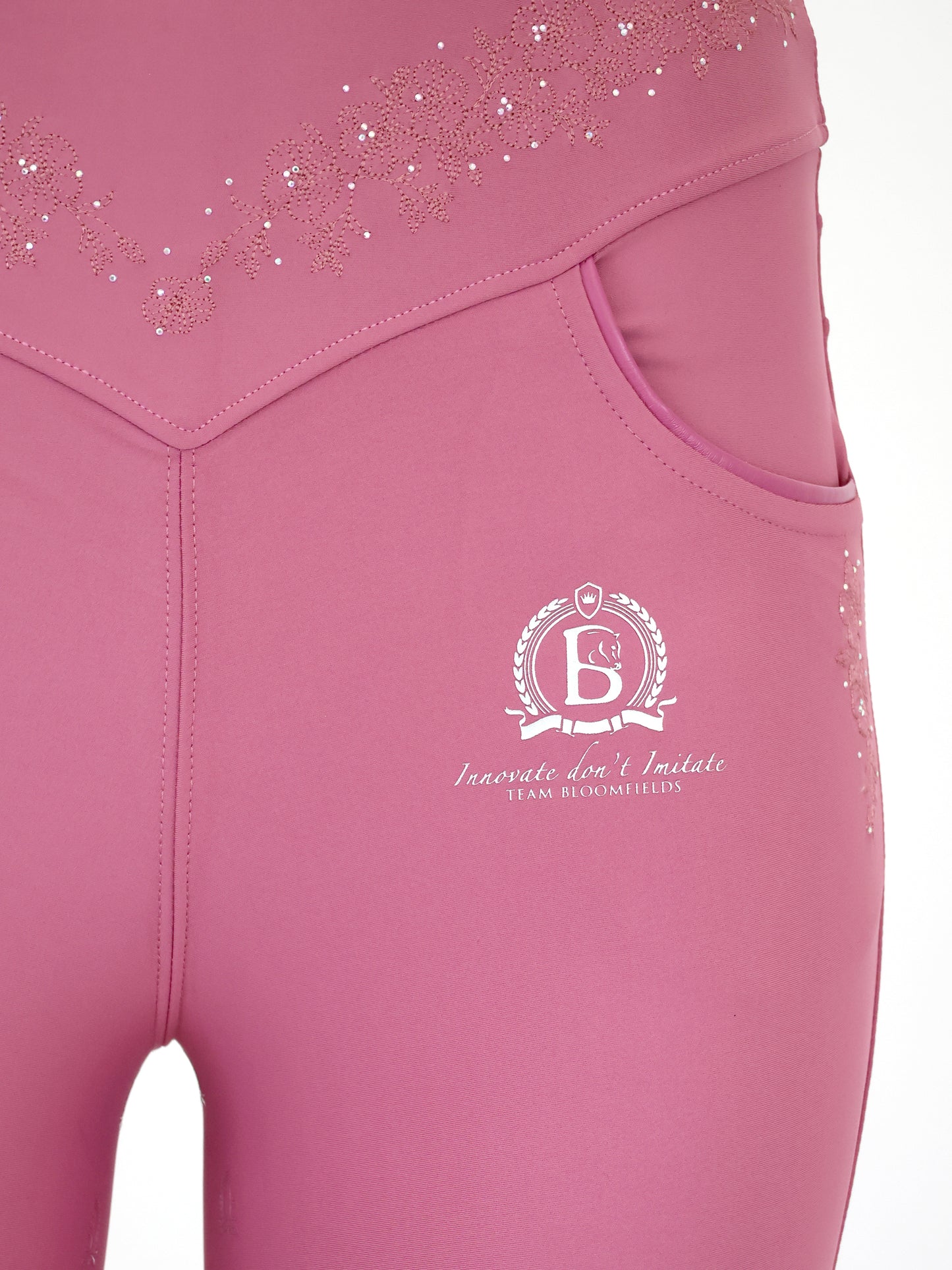 Close-up of tonal Bloomfields crest on the left leg of the Old Rose Anemone Leggings