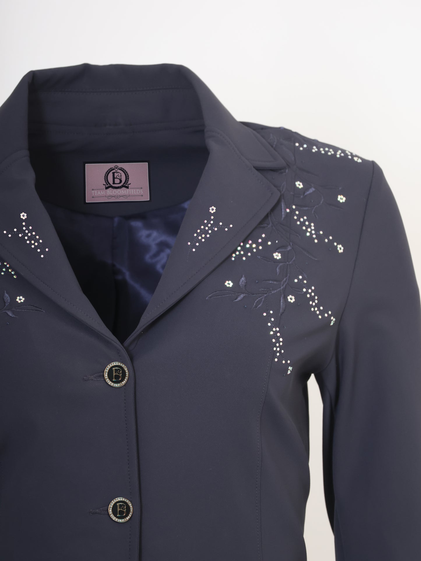 Close-up of embroidered floral vine and crystal embellishment detail on the Navy Vivienne Show Jacket